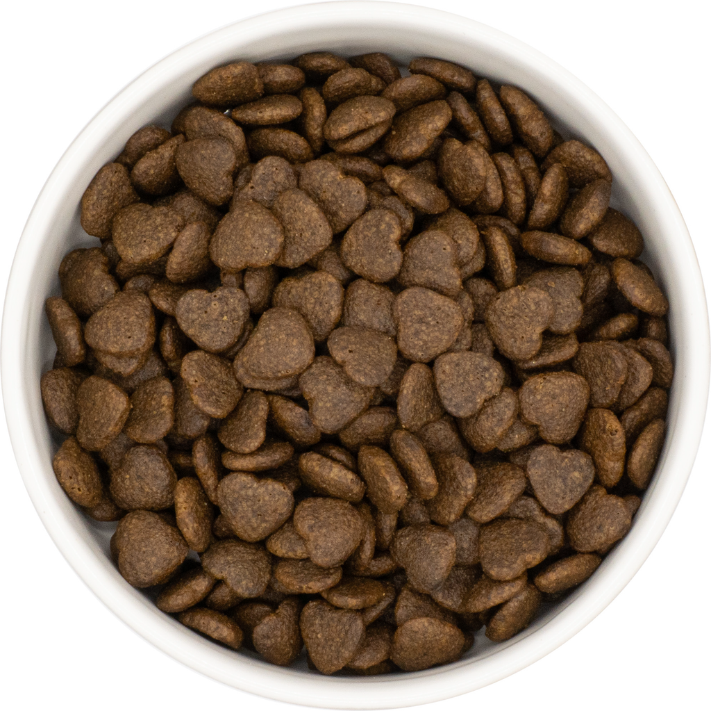 White bowl filled with brown heart-shaped McDug Health and wellness dog food on a white background